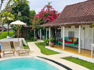 einen Hinterhof mit einem Pool und einem Haus in der Unterkunft Janur Bungalow in Borobudur