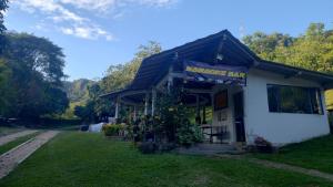 un pequeño edificio blanco con un cartel en él en CAMPING Y PISCINA LOS NARANJOS, en Nimaima