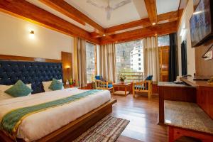 - une chambre avec un grand lit et une grande fenêtre dans l'établissement FabHotel La Kailasha Regency, à Manali