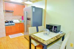 eine Küche mit einem Tisch und einer Mikrowelle in der Unterkunft G-503 Secret AZIT in Gunsan in Gunsan + 10 Fotos