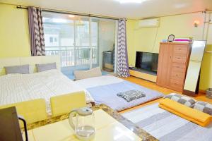 ein Schlafzimmer mit einem großen Bett und einem Fernseher in der Unterkunft G-503 Secret AZIT in Gunsan in Gunsan