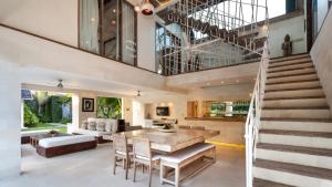 a living room with a wooden table and a staircase at Casa Mateo Villa in Seminyak