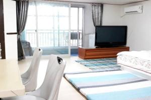 a living room with two chairs and a flat screen tv at G-817 Gunsan Business and Leisure Trip, 5mins to Eunpa Park in Gunsan-si