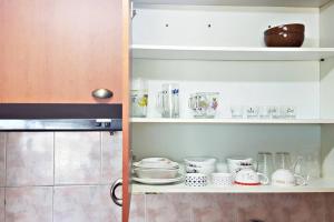 a kitchen shelf with dishes and other items on it at G-817 Gunsan Business and Leisure Trip, 5mins to Eunpa Park in Gunsan-si
