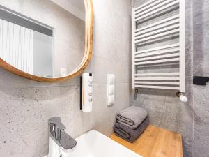 un baño con lavabo y espejo en Apartament typu studio przy Nawrot 50, en Łódź 16 fotos más