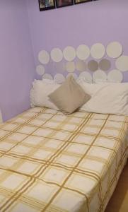 a bed with white pillows and a purple wall at Quarto privado somente para mulheres e banheiro exclusivos - demais areas compartilhadas in Maceió
