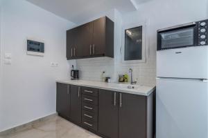 a kitchen with brown cabinets and a white refrigerator at ARIS in Exarchia in Athens