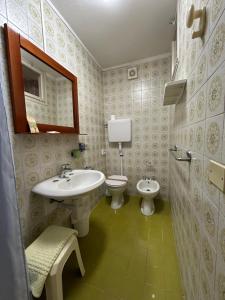 ein Badezimmer mit einem Waschbecken, einem WC und einem Spiegel in der Unterkunft Albergo da Pina in Lazise
