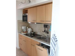 a kitchen with wooden cabinets and a sink at Chudzik Modern retreat in Rerik +13 photos