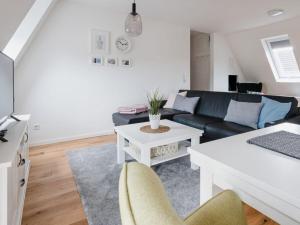 sala de estar con sofá negro y mesa en Torbogenhuus No 5 en Norderney