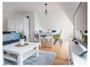 a living room with a white table and chairs at Torbogenhuus No 5 in Norderney