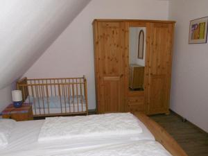 - une chambre avec un lit et une armoire en bois dans l'établissement Beachcomber's nest, à Nessmersiel
