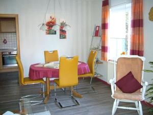 a dining room with a table and yellow chairs at Luise Bernhardt Modern retreat in Poppenhausen