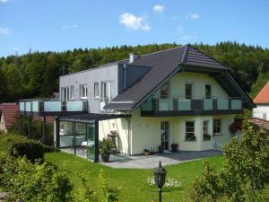 a large white house with a black roof at Luise Bernhardt Modern retreat in Poppenhausen