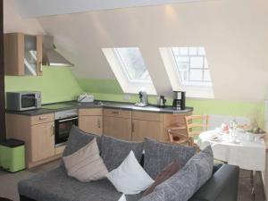 een woonkamer met een bank en een keuken bij Am Lustgarten Modern retreat in Wernigerode