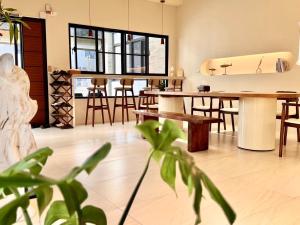 een kamer met houten tafels en stoelen en een keuken bij 悠日 Lazy Days 澎湖民宿 in Magong