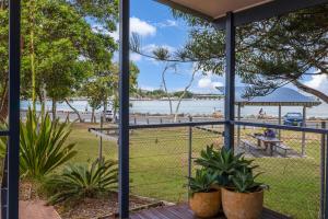 una vista sulla spiaggia da un portico con piante di Reflections Tuncurry - Holiday Park a Tuncurry