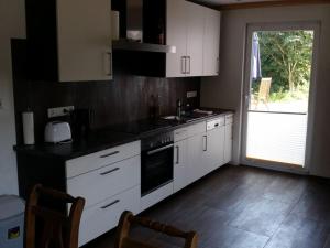 uma cozinha com armários brancos e bancadas pretas em Borkum Freedom 2 em Borkum