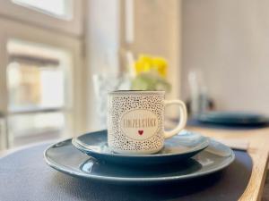 a coffee cup sitting on a plate on a table at HOMELIKESTAY unique piece in Wernigerode