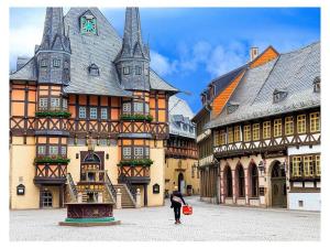 a woman standing in front of a large building at HOMELIKESTAY unique piece in Wernigerode