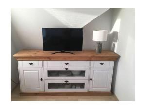 Biała szafka z telewizorem na górze w obiekcie Holiday home Fischer w mieście Juist