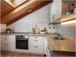 a kitchen with white cabinets and a sink at Angerer-the holiday apartment in Berchtesgaden