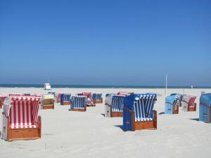 um grupo de cadeiras de praia sentadas na praia em in the Fischer house Lütje Stuv em Juist