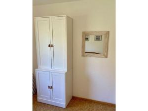 a white cabinet in a room with a mirror at in the Fischer house Lütje Stuv in Juist