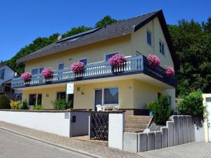 a house with pink flowers on a balcony at Palatinate Forest Comfortable holiday residence in Silz