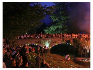 Une foule de gens debout sur un pont la nuit dans l'établissement Former village school, à Stockhausen-Illfurth