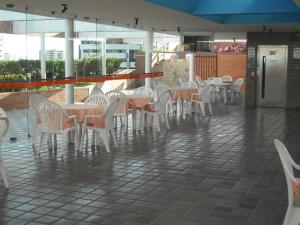 a row of tables and chairs on a patio at Estúdio Ibiza em Jatiúca in Maceió