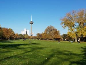 een groep mensen in een park met een toren op de achtergrond bij Dream view over Cologne in Keulen