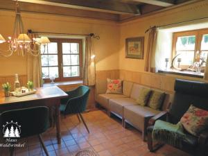 uma sala de estar com um sofá e uma mesa em Nagelsmederij in het huis Waldwinkel em Aschau im Chiemgau