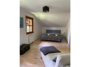 um quarto com uma cama e um sofá em Chalet Salzeder Modern retreat em Bayerisch Gmain