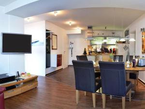 a kitchen and living room with a table and chairs at Siam Comfortable Holiday Residence in Borkum