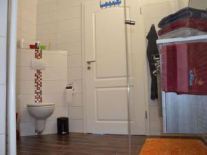 a bathroom with a toilet and a white door at Siam Comfortable Holiday Residence in Borkum +31 photos