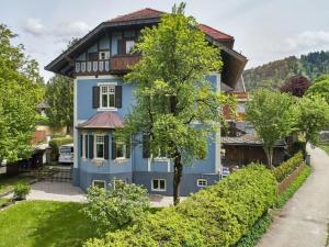 een blauw huis met een boom ervoor bij in the Blue House - ground floor in Garmisch-Partenkirchen