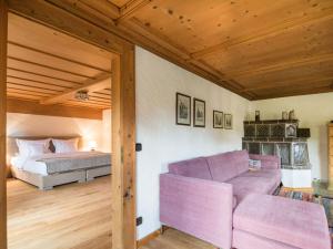 um quarto com uma cama e um sofá roxo em Holiday apartment HANS in the Schusterhäusl em Achenmühle