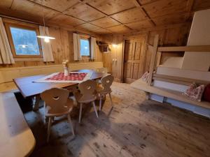 una habitación con mesa y sillas en una cabaña en Englhof Modern retreat en Corvara in Passiria