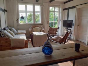 Holperdorp Modern retreat في Lienen: غرفة معيشة مع مزهرية على طاولة