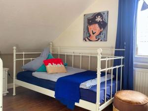 a childs bedroom with a white bed with blue sheets at Colorful Cow Modern Retreat in Borkum