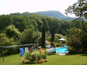a garden with a swimming pool and trees in the background at Old Mill Fam Menz 