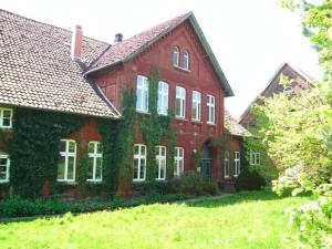 een groot rood bakstenen huis met klimop erop bij The large holiday apartment in WÃ¶lpinghausen