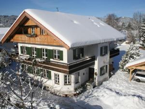 dom ze śniegiem na górze w obiekcie Platzl in the sacristan's house w mieście Lenggries