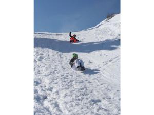 two people are on a snowboard in the snow at Platzl in the sacristan's house in Lenggries