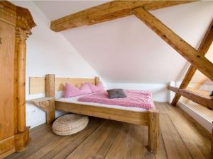 Un dormitorio con una cama con almohadas rosas. en Platzl in the sacristan's house en Lenggries