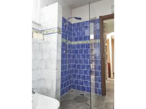 een blauwe betegelde douche met een toilet in de badkamer bij Via Roma 53 - Bedero in Brezzo