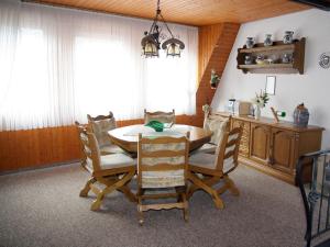 Un comedor con mesa y sillas de madera. en Brown Modern Retreat, en Sankt Aldegund