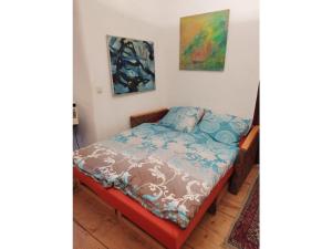 a bed in a room with two paintings on the wall at Rust pile Modern retreat in Konstanz