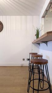 2 taburetes en una habitación con paredes blancas en City Centre Apartment by Noire Property, en Mánchester